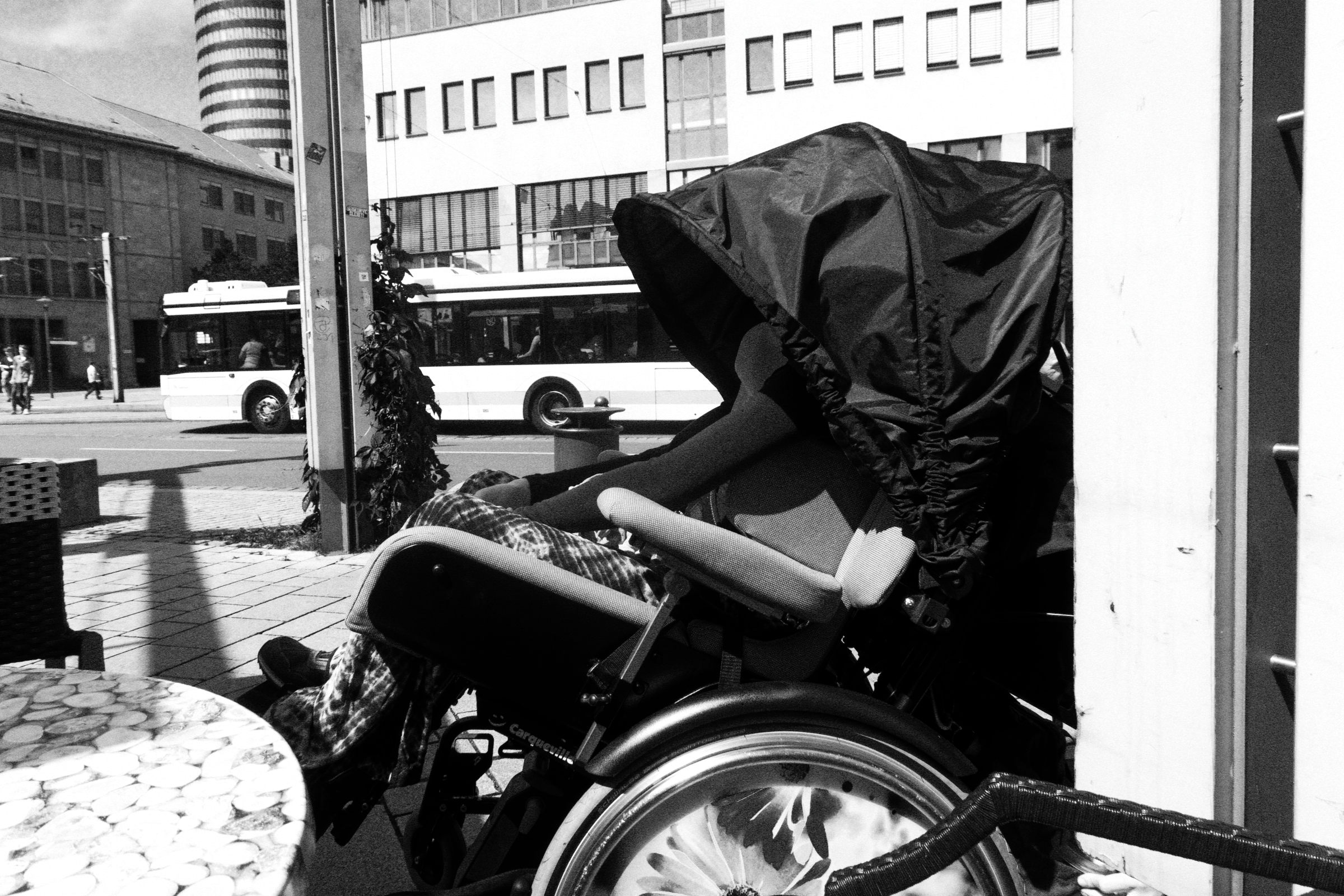 Rollstuhl mit Verdeck in der Stadt in Schwarz-Weiß