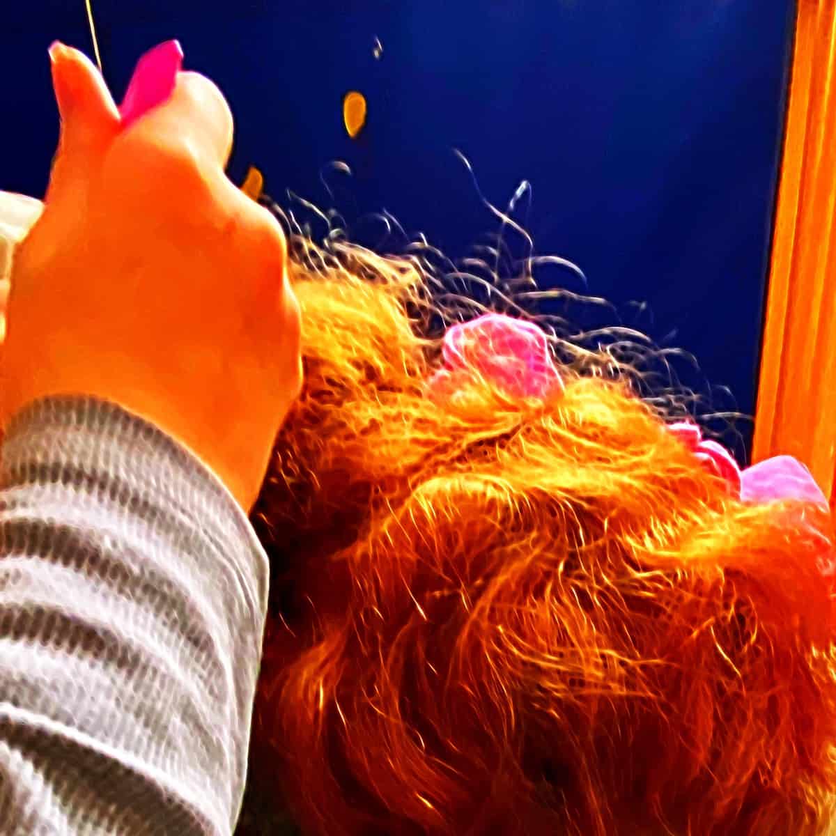 Kinderhand kämmt Haare vom Intensivkind